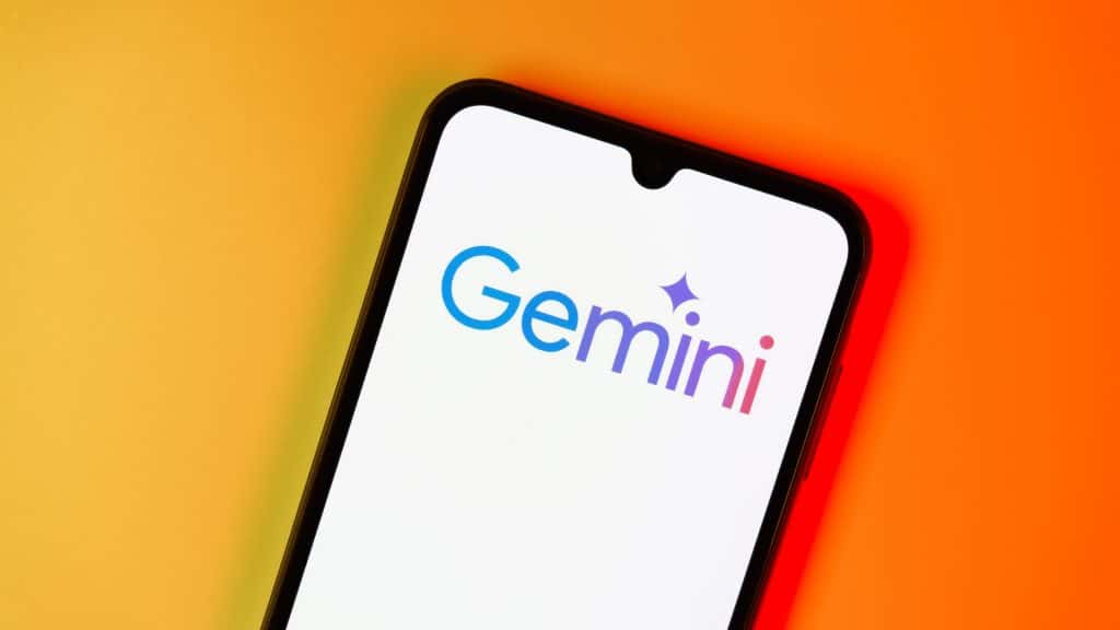 Celular com logomarca do Gemini na tela na frente de fundo laranja com efeito degradê